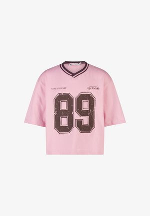 Roze shirt met korte mouwen en donker gestreepte V-hals, groot verweerd nummer "89", tekst "COME AS YOU ARE" en klein "New York Club" logo aan de voorkant.
