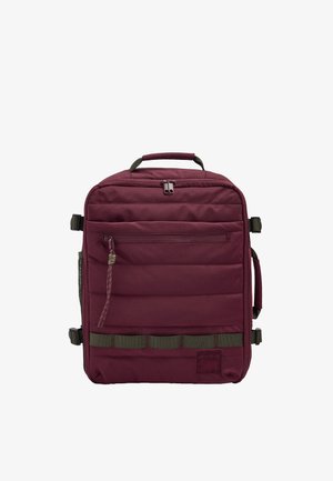 Kwadratowy bordowy plecak z wyściełanym przodem, górną rączką, bocznymi paskami, przednią kieszenią na suwak i zielonymi poziomymi pętlami.