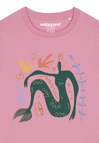 Rosa T-Shirt mit einer grünen, meerjungfrauenähnlichen Figur, die mit abstrakten Mustern verziert ist, umgeben von dekorativen Blättern und Formen in Gelb, Orange und Blau.