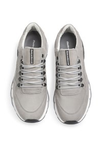Sneaker grigi con un mix di materiali lisci e testurizzati, dotati di un collare imbottito, lacci grigi e dettagli in gomma nera sulla suola.