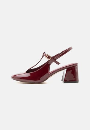 Fényes bordó női slingback cipő blokk sarokkal, hegyes orral és T-pánttal, arany csattal.