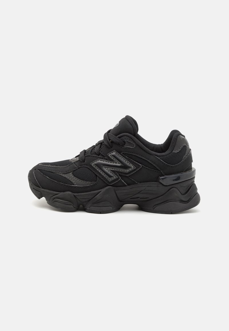 Chaussure de sport noire en maille et matériaux synthétiques. Dotée d'une semelle épaisse, d'un col rembourré et d'accents réfléchissants pour la visibilité.