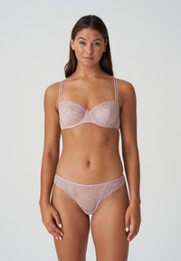 Jasnoróżowy komplet bielizny koronkowej, w skład którego wchodzi biustonosz typu half-cup z delikatnym haftem w kwiaty i regulowanymi ramiączkami, w zestawie z pasującymi koronkowymi majtkami.