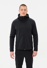 Giacca in pile nera con zip e cappuccio, dotata di due tasche laterali, una texture liscia e un design aderente. Branding discreto sul petto.