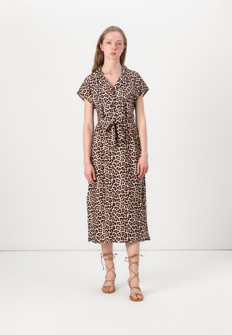 Rochie cu imprimeu leopard, cu mâneci scurte, talie legată și lungime midi. Fabricată dintr-un material ușor, cu o textură netedă. Stilizată cu sandale cu curea.
