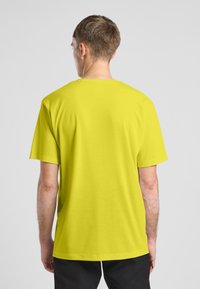 T-shirt a maniche corte, con scollo rotondo, di un vivace giallo, realizzato in tessuto morbido con una vestibilità comoda e dettagli di cucitura ridotti al minimo.