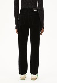 Zwarte corduroy broek met een rechte pasvorm, met twee achterzakken en een merklabel op de tailleband. Gestructureerde stof met brede pijpen.