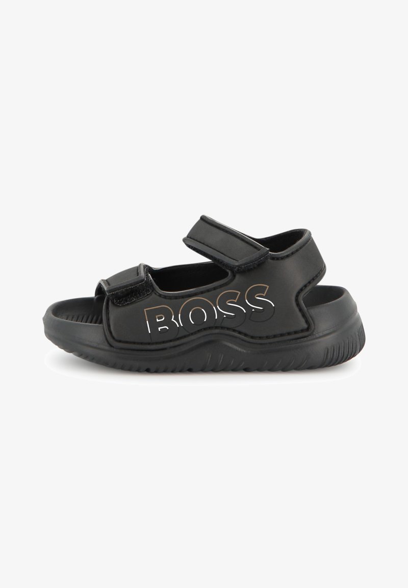Sandalias negras con correas ajustables, suela de goma y marca "BOSS" en acabado metálico. Diseño abierto para transpirabilidad y comodidad.
