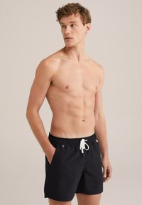 Schwarze Schwimmshorts aus leichtem Material, mit elastischem Bund, Kordelzugverschluss und Seitentaschen. Einfaches Design ohne Muster.
