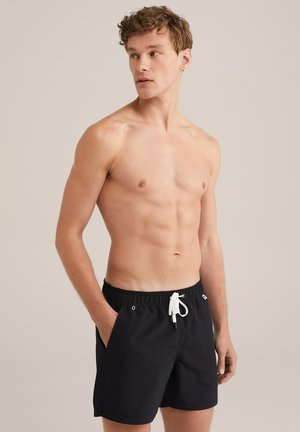Schwarze Schwimmshorts aus leichtem Material, mit elastischem Bund, Kordelzugverschluss und Seitentaschen. Einfaches Design ohne Muster.