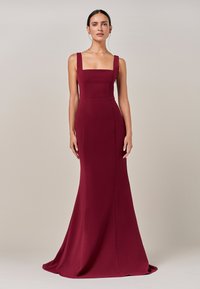 Bordo brezrokavnik z kvadratnim izrezom, oprijetim zgornjim delom in razširjenim spodnjim delom. Gladek tekstura in čiste linije skozi celoten dizajn.