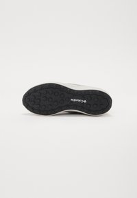 Columbia sneaker sole, black rubber with a hexagonal pattern. Light-colored midsole, featuring the brand logo in white.