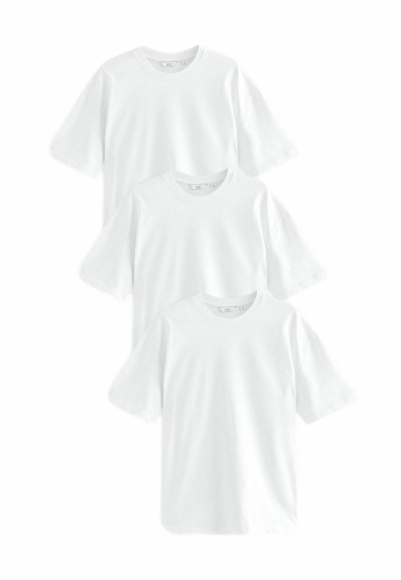 Drie witte katoenen t-shirts opgestapeld. Elk heeft een ronde hals en korte, losse mouwen. Glad oppervlak, geen patronen of accenten.