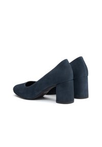 Granatowe zamszowe czółenka na słupku z zaokrąglonym noskiem i otwartym wycięciem po bokach. Obcas jest szeroki i teksturowany dla większej stabilności.