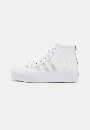Biały wysoki sneaker z białymi sznurowadłami, opalizującymi trzema paskami po boku oraz grubą białą gumową podeszwą.