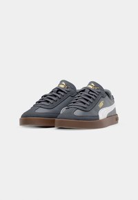 Sneakers w ciemnoszarej zamszowej i syntetycznej tkaninie, z białymi akcentami, złotym logo i brązową gumową podeszwą. W zestawie okrągłe sznurówki.