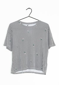 Striped short-sleeve shirt in black and white, with floral embroidery accents. Lightweight fabric, round neckline, and a relaxed fit design.