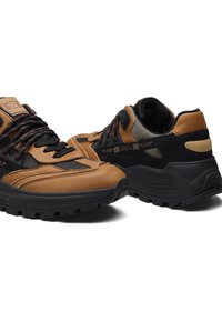 Sneaker in pelle marrone e rete nera con dettagli testurizzati, suola robusta nera e accenti a contrasto, con lacci e marchio sulla linguetta.