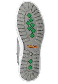 Suela de zapato de goma gris con tacos de tracción en patrón de diamante verde, lado blanco y logo de "Timberland" en naranja cerca del centro.