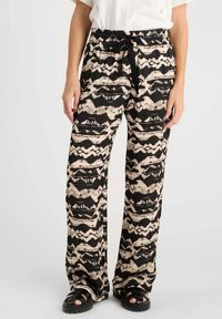 Pantalons larges noirs et beiges à motifs, avec une taille élastique, un système de fermeture à cordon et une coupe décontractée. Le matériau semble léger et doux.