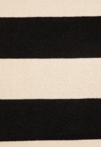 Svart och krämfärgat randigt tyg med växlande breda svarta och smala krämfärgade band. Slät textur med stickad framtoning.