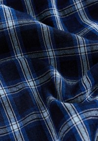 Tumši zils un gaiši zils/plīdums ar teksturētu audumu. Iespējami pārmaiņus svītriņi un maiga virsma, parādot maigas krokas un grumbas.