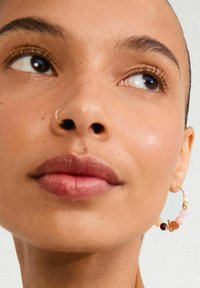 Gold hoop earring with assorted beads in pink, peach, brown, and white, featuring a textured detail and a polished finish.