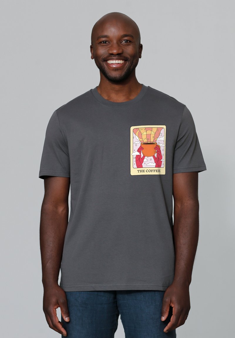 Graues Baumwoll-T-Shirt mit einem bunten Grafikdruck von Händen, die eine Schüssel halten, über der ein Heißluftballon schwebt. Mit kurzen Ärmeln und Rundhalsausschnitt.