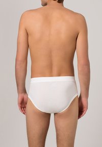 Bóxers de algodón blanco para hombres con una textura suave, cinturilla elástica y un corte ajustado, vistos desde atrás.
