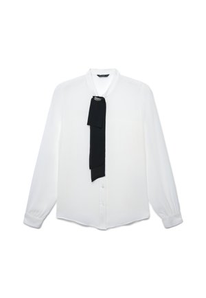 Blusa bianca a maniche lunghe con bottone frontale e una sciarpa decorativa nera appuntata vicino al colletto.