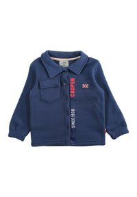 Veste polaire bleu marine avec col, fermeture à boutons sur le devant et une poche poitrine. Présente un texte rouge "COOPER" et "SINCE 1908" à côté d'un écusson du drapeau britannique.