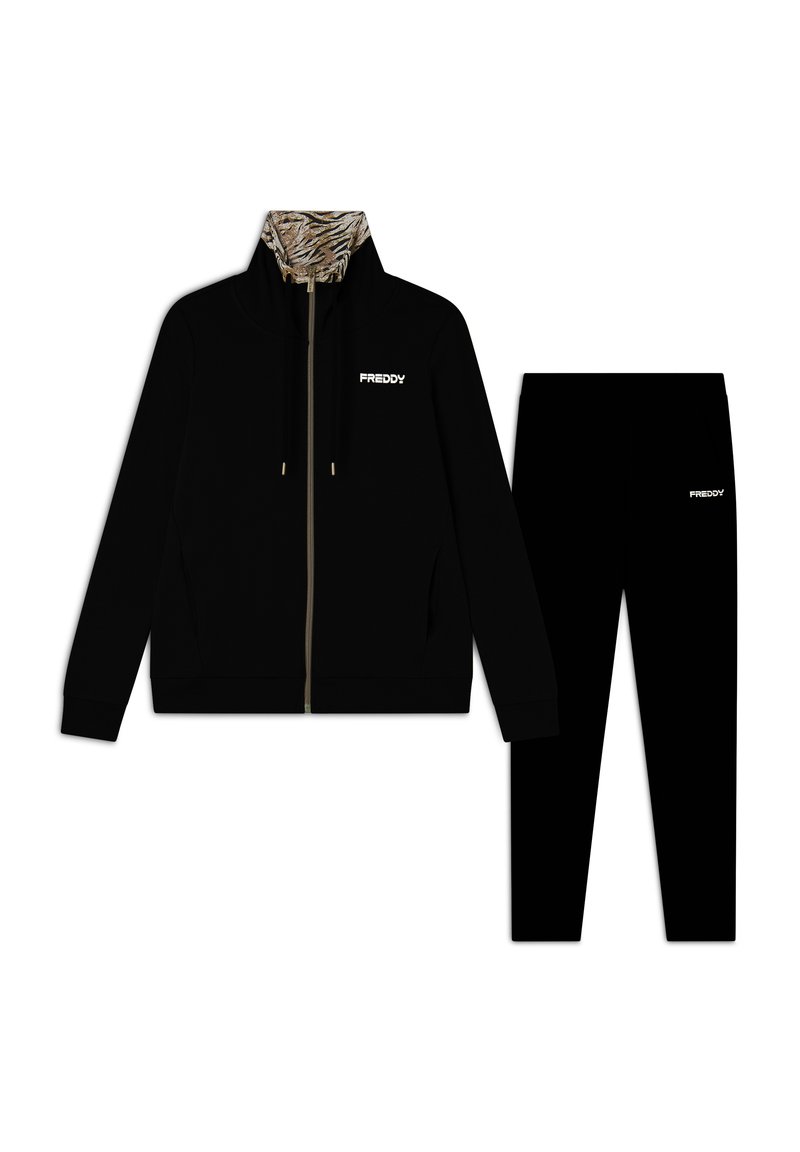 Chaqueta negra con cremallera y cuello de estampado de tigre, acompañada de pantalones negros a juego. Ambos presentan el logo "FREDDY" en blanco. Textura de tela suave.