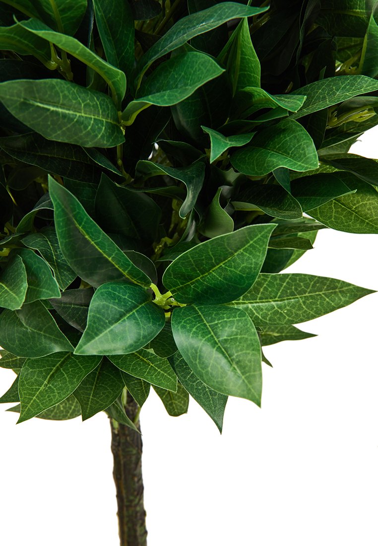 Plante artificielle avec des feuilles vertes brillantes et denses, présentant des veines complexes, disposées sur une tige réaliste à texture brun. 