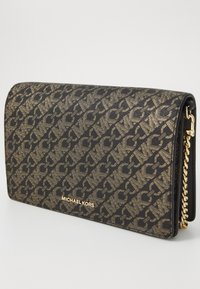 Juodas ir auksinis Michael Kors delninukas su monograma, lygia tekstūra, stačiakampio formos ir auksinės spalvos grandinėlės rankena.