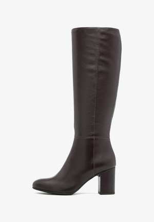 Brązowy skórzany, sięgający kolan, but o eleganckim kształcie, zaokrąglonym nosku i masywnej podeszwie. Charakteryzuje się minimalnym przeszyciem i gładką teksturą.