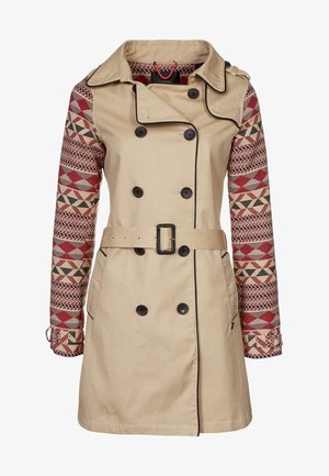 Beige trench coat with patterned red and gray sleeves, double-breasted front, black buttons, and a matching belt at the waist.