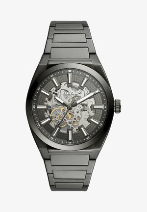 Black metal wristwatch with a skeleton design, featuring a gray patterned dial and silver-tone markers, highlighting intricate inner mechanics.