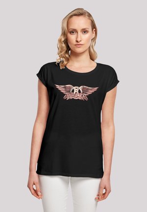 Schwarzes Baumwoll-T-Shirt mit Rundhals und umgeschlagenen Ärmeln, das auf der Vorderseite einen auffälligen Druck von Flügeln und Logo in Rot und Weiß zeigt.
