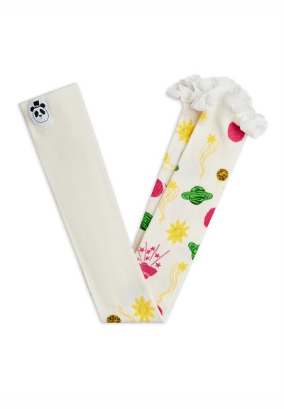 Mallas infantiles color crema con soles amarillos, planetas verdes, estrellas rosas y volantes de encaje blanco en los tobillos, dobladas sobre fondo blanco.