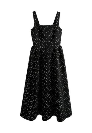 Black cotton dress with white polka dots, square neckline, and adjustable straps. Flared silhouette with a mid-length hemline.