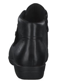 Bottines noires en cuir avec une texture lisse, une forme arrondie et une fermeture à fermeture éclair sur le côté, avec des accents de couture minimalistes.