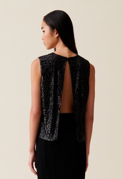 Top nero con paillettes, collo alto, schiena scoperta e senza maniche; texture liscia con un drappeggio fluido.