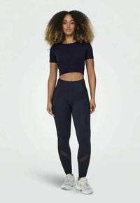 Lahti sininen crop top ja korkeavyötäröiset legginsit joustavasta kankaasta, joissa on verkkoaukkoja nilkoissa ja ribbausta. Sisältää tennarit.