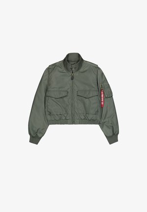 Veste bomber vert olive en matériau synthétique lisse. Elle possède une fermeture éclair sur le devant, deux grandes poches poitrine et un tirette rouge.