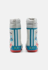 Bottes imperméables blanches avec des poignets gris, des rayures bleues et des autocollants de personnages colorés. Semelles en caoutchouc rouges pour une meilleure adhérence. Logo sur le talon.