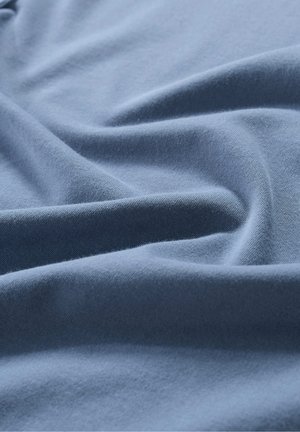Blauer Baumwollstoff mit einer glatten Textur und sanftem Fall. Das Material zeigt subtile Falten und Knicke, die seine weiche Qualität unterstreichen.