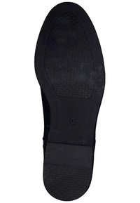 Suola di una scarpa nera con un motivo di grip testurizzato e taglia 37 contrassegnata al centro su uno sfondo bianco.