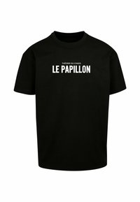 Sort bomulds t-shirt i sort med rund hals, korte ærmer og hvidt trykt tekst: "THÉORIE DU CHAOS LE PAPILLON" centreret på fronten.
