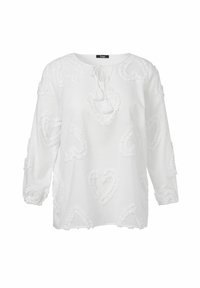 Weiße Bluse mit Rundhalsausschnitt, langen Ärmeln und strukturierten Herzmustern. Mit einer Bindung am Hals.