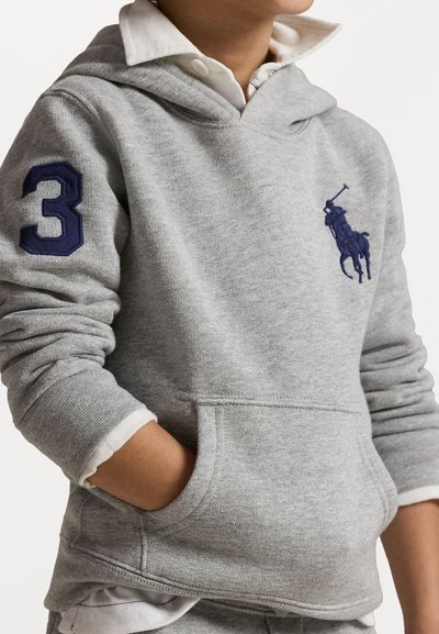 Grå hettegenser med kengurulomme, marineblåt nummer "3" på ermet, og et lite marineblått polo-spiller emblem på brystet. Teksturert stoff.